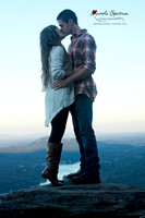 Engaged couple kisses on the overlook at Chimney Rock
