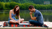 Couple plays scrabble on the dock of a lake