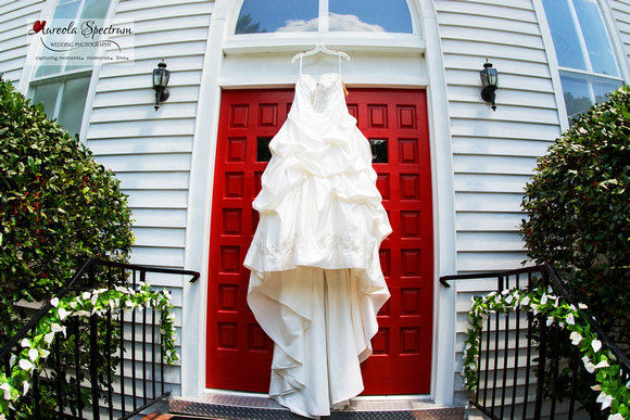 Brial gown hanging on chruch's red door