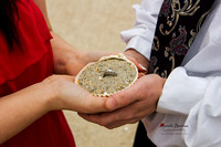 Engaged couple holds seashell with engagement ring.