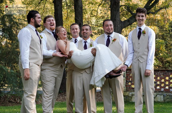 Candid of groomsmen holding bride
