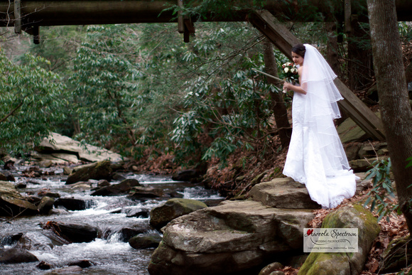beautiful bride standing beside a roaring river
