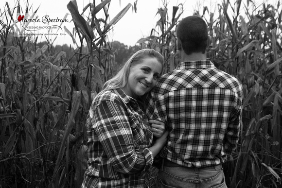 Couple in corn field wearing plaid.