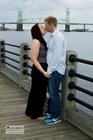 Couple kisses at the boardwalk in Wilmington, NC.