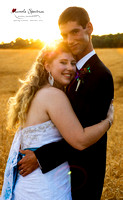 Bride and groom portrait at sunset posing in a golden lit field.
