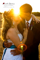 Bride and groom kiss in sun rays