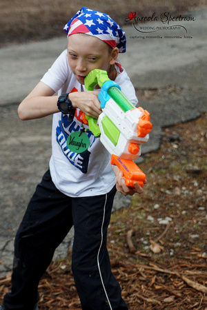 Heart kid plays with water gun at camp luck.