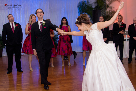 Groom twirls bride during first dance.
