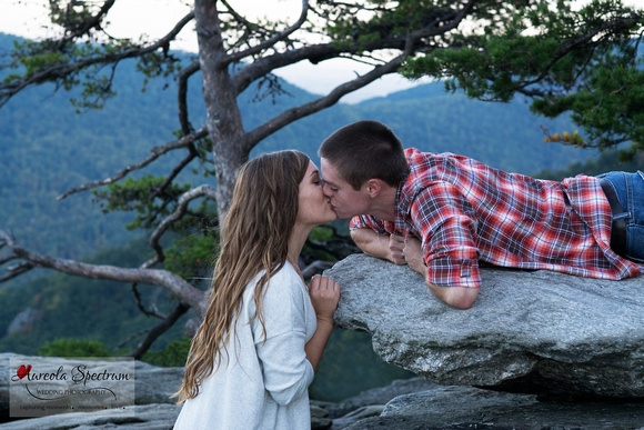 Couple kisses on rock in Chimney Rock, NC