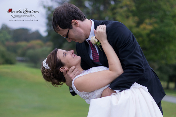 Bride and groom's portrait as they dip on a golf course.