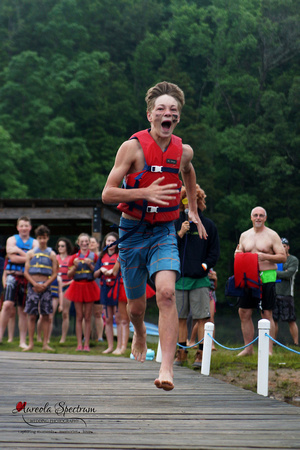 Heart kid runs down docks at camp luck family camp.