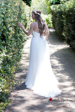 Bride walks along the hedges at Daniel Stowe Botanical Garden.