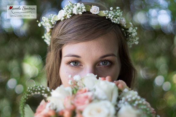 Bride hides face behind her flower bouquet. 